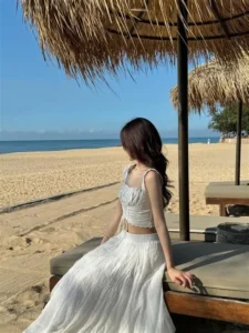 Outfit du lịch biển với váy trắng thanh lịch, phong cách thời trang nghỉ dưỡng phù hợp để dạo biển, chụp ảnh check-in và tận hưởng kỳ nghỉ mùa hè.
